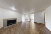 Located at 900 SE Park Crest Ave in Vancouver, Washington, this 2-bedroom, 1-bathroom single-floor residence offers a functional and comfortable layout. The living room serves as the centerpiece of the home, featuring rich wood-style laminate flooring, neutral white walls, and a tiled fireplace with warm wood trim — an inviting focal point for the space. Vertical blinds allow natural light to filter in while providing privacy. The kitchen is designed for practicality, showcasing warm wood cabinetry, a peninsula with a light-toned countertop and a built-in cooktop, a dishwasher, refrigerator, and a window overlooking the outdoors. Overhead cabinetry with a mirrored accent adds depth to the space. Both bedrooms are carpeted and feature baseboard heaters, windows with vertical blinds that bring in natural views of surrounding greenery, and a clean, neutral palette. The bathroom is straightforward and well-appointed, offering a full tub-shower combination with white surround, a toilet, and wood-style flooring that ties into the rest of the home. A dedicated closet provides additional storage. The overall layout flows efficiently, making good use of the available space throughout.