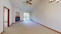 Located at 1105 Hawthorne Place in Brookfield, Wisconsin, this single-floor, three-bedroom, two-bathroom home offers a well-designed layout with comfortable, functional living spaces throughout. The living room serves as a central gathering area, featuring vaulted ceilings with a ceiling fan, plush carpeting, a built-in gas fireplace, and a sliding glass door that opens to a private balcony overlooking lush greenery. The kitchen is equipped with warm oak cabinetry, stainless steel appliances including a range and refrigerator, and light tile flooring, with a convenient pass-through that connects to the adjacent living area. A dedicated laundry room with utility hookups and additional storage adds everyday practicality. The three bedrooms are carpeted and filled with natural light from sizable windows. The spacious primary bedroom includes a generous walk-in closet outfitted with wire shelving on both sides. Two full bathrooms feature oak vanities, tile flooring, and large mirrors. Warm-toned wood trim and door framing carry throughout the hallway and rooms, giving the home a cohesive, classic character. The layout flows naturally from the main living areas through a central hallway connecting all bedrooms and bathrooms with ease.