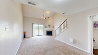 Located in Houston, TX, this two-story home offers 2 bedrooms and 4 bathrooms across a thoughtfully laid-out floor plan. The main level serves as the heart of the home, featuring a combined kitchen and living room area highlighted by soaring vaulted ceilings and a ceiling fan that enhances the sense of openness. A cozy fireplace with tile surround anchors the living room, while a carpeted staircase with sleek metal railings connects to the upper level. The kitchen is equipped with gray shaker-style cabinetry, light quartz countertops, black appliances including an electric range and built-in microwave, and warm hardwood-style flooring. A dedicated laundry area with built-in shelving provides additional storage and functionality. The bathrooms feature a mix of hardwood-style and tiled flooring, with one bathroom showcasing a jetted soaking tub with shower combo and a vanity with ample cabinetry. Both bedrooms are generously proportioned with plush carpet, ceiling fans, and vaulted ceilings that add volume and comfort. The spacious primary bedroom includes direct access to a bathroom and a closet. The second bedroom is equally well-sized with its own ceiling fan. Throughout, neutral tones create a clean, cohesive aesthetic.