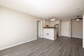 This 2-bedroom, 2-bathroom residence is thoughtfully laid out across a single floor, offering an efficient and comfortable living arrangement. The open-concept living and kitchen area serves as the heart of the home, featuring light wood-look vinyl flooring that extends throughout the main living spaces. The kitchen is equipped with white cabinetry, stainless steel appliances including a range and refrigerator, and a peninsula counter that provides both workspace and a natural division between the kitchen and living area. The living room is bright and airy, benefiting from a sliding glass door that opens to a private balcony with views of surrounding greenery, allowing abundant natural light to fill the space.

Both bedrooms are carpeted and generously proportioned, with the primary bedroom offering ample space and a closet. Large windows dressed with vertical blinds allow natural light to filter in while maintaining privacy. Each bedroom is served by its own full bathroom, each featuring a tub-shower combination with chrome fixtures and clean white finishes. The neutral warm-beige color palette throughout creates a cohesive and inviting ambiance, while the consistent use of light tones and natural light enhances the overall sense of openness in the home.