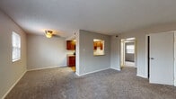 This single-floor residence in Lexington, Kentucky, offers a practical and comfortable layout designed for easy everyday living. The open living area is spacious and bright, finished with plush wall-to-wall carpeting and neutral gray walls that create a clean, welcoming atmosphere. A textured ceiling adds subtle character throughout the common areas. The kitchen is a standout feature, showcasing rich medium-toned wood cabinetry, granite-look countertops, and hardwood flooring. It is fully equipped with black appliances including a gas range, built-in microwave, dishwasher, and refrigerator. A convenient pass-through window connects the kitchen to the living area, enhancing the open feel of the space. Multiple bedrooms offer generous proportions, each with soft carpeting, neutral walls, and windows fitted with blinds that allow natural light to filter in. The full bathroom features hardwood flooring, wood cabinetry with matching granite-look countertops, a tiled tub-shower combination, and clean white walls. Throughout the residence, the consistent use of neutral tones, carpet in living spaces, and hardwood in functional areas creates a cohesive and functional environment well-suited for comfortable daily living.