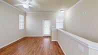 Located at 5202 Auburn St in Lubbock, TX, this single-story 1-bedroom, 1-bathroom home offers a thoughtfully designed layout with comfortable living spaces throughout. The main living area welcomes you with warm hardwood-style flooring, crown molding, a ceiling fan, and multiple windows fitted with blinds that allow ample natural light to fill the room. A glass-paneled exterior door provides additional brightness and outdoor access directly from the living space. The kitchen is a functional highlight, featuring light wood cabinetry with crown molding detail, granite countertops, a curved breakfast bar peninsula, stainless steel appliances including a refrigerator, range, and microwave, track lighting, and a window above the sink. An in-unit laundry area with a full-size washer and dryer is conveniently accessible just off the kitchen. The bedroom is carpeted for comfort, includes a ceiling fan, built-in shelving, and a private exterior door, offering both storage and accessibility. A dedicated closet provides organized storage space. The bathroom is well-equipped with a granite-topped vanity, light wood cabinetry, a tub-shower combination, and a multi-bulb vanity light fixture. Neutral warm-toned walls and consistent finishes throughout contribute to a cohesive and inviting ambiance.