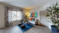 This single-floor residence offers a thoughtfully designed layout that balances comfort and modern style across multiple rooms. The living area features wood-look flooring, large windows with decorative curtains that invite natural light, and an open, welcoming atmosphere with ample space for furniture arrangement. The kitchen is equipped with stainless steel appliances, including a gas range, built-in microwave, and refrigerator, complemented by dark wood cabinetry, a light quartz-style countertop, and a soft green subway tile backsplash — a clean and functional cooking space. The bedrooms are carpeted for warmth and comfort, each featuring windows with natural light, neutral gray walls, and generous closet space. One bedroom includes a walk-in closet with built-in organization. The bathrooms are finished with dark vanity cabinetry, white countertops, and wood-look flooring. One bathroom features a soaking tub with shower combination, while another offers an open vanity area adjacent to the bedroom. Throughout the space, the design aesthetic is modern and contemporary, with consistent neutral tones accented by bold decorative choices, creating a vibrant yet cohesive living environment.