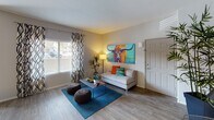 This single-floor residence offers a thoughtfully designed layout that balances comfort and modern style across multiple rooms. The living area features wood-look flooring, large windows with decorative curtains that invite natural light, and an open, welcoming atmosphere with ample space for furniture arrangement. The kitchen is equipped with stainless steel appliances, including a gas range, built-in microwave, and refrigerator, complemented by dark wood cabinetry, a light quartz-style countertop, and a soft green subway tile backsplash — a clean and functional cooking space. The bedrooms are carpeted for warmth and comfort, each featuring windows with natural light, neutral gray walls, and generous closet space. One bedroom includes a walk-in closet with built-in organization. The bathrooms are finished with dark vanity cabinetry, white countertops, and wood-look flooring. One bathroom features a soaking tub with shower combination, while another offers an open vanity area adjacent to the bedroom. Throughout the space, the design aesthetic is modern and contemporary, with consistent neutral tones accented by bold decorative choices, creating a vibrant yet cohesive living environment.