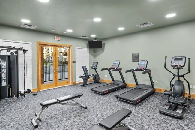 Elevate your fitness journey at Southgate Apartments, where our state-of-the-art gym awaits. Enjoy a bright, welcoming space equipped with modern cardio machines and weight training options. Start your new lifestyle today—schedule a tour now! - Southgate Apartments