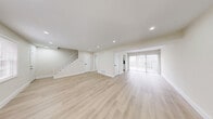 Located in Indianapolis, this two-story, 3-bedroom, 1-bathroom home offers a clean, modern aesthetic with thoughtful updates throughout. The main floor features a generously sized living area with light wood-tone luxury vinyl flooring, recessed lighting, and large sliding glass doors that fill the space with natural light. The kitchen is well-appointed with white shaker cabinetry accented by matte black hardware, a stainless steel refrigerator and dishwasher, a subway tile backsplash, and a sleek undermount sink — all complemented by light wood flooring that carries through from the living area. A carpeted staircase with a clean white balustrade connects the two floors. Upstairs, three bedrooms offer plush carpet flooring and neutral walls. The spacious primary bedroom includes a dedicated closet and direct access to the full bathroom. The additional bedrooms provide natural light through windows with blinds. The full bathroom is finished with grey tile flooring, a white vanity with matte black fixtures, and a tub-shower combination featuring a striking multi-toned tile surround. Recessed lighting and a consistent neutral color palette create a bright, cohesive feel throughout the home.