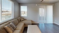 This single-story, three-bedroom, two-bathroom residence offers a well-organized layout designed for comfortable everyday living. The kitchen serves as a functional centerpiece, featuring stainless steel appliances including a gas range, built-in microwave, refrigerator, and dishwasher. White shaker-style cabinetry extends to the ceiling, providing generous storage, while a subway tile backsplash and wood-look flooring add a clean, contemporary aesthetic. A large window fills the kitchen with natural light and offers exterior views.

The living area continues the wood-look flooring and features multiple windows alongside a sliding glass door, allowing abundant natural light and outdoor access. Each of the three bedrooms is finished with plush carpeting and windows that bring in natural light. The primary bedroom includes an en-suite bathroom and access to a walk-in closet area.

The two bathrooms are finished consistently with neutral-toned cabinetry, integrated sinks, and chrome fixtures. One bathroom features a tub-shower combination, while the other offers a glass-enclosed walk-in shower. A dedicated laundry room houses a full-size front-loading Whirlpool washer and dryer set beneath ample white cabinetry, adding significant convenience and storage to the space.
