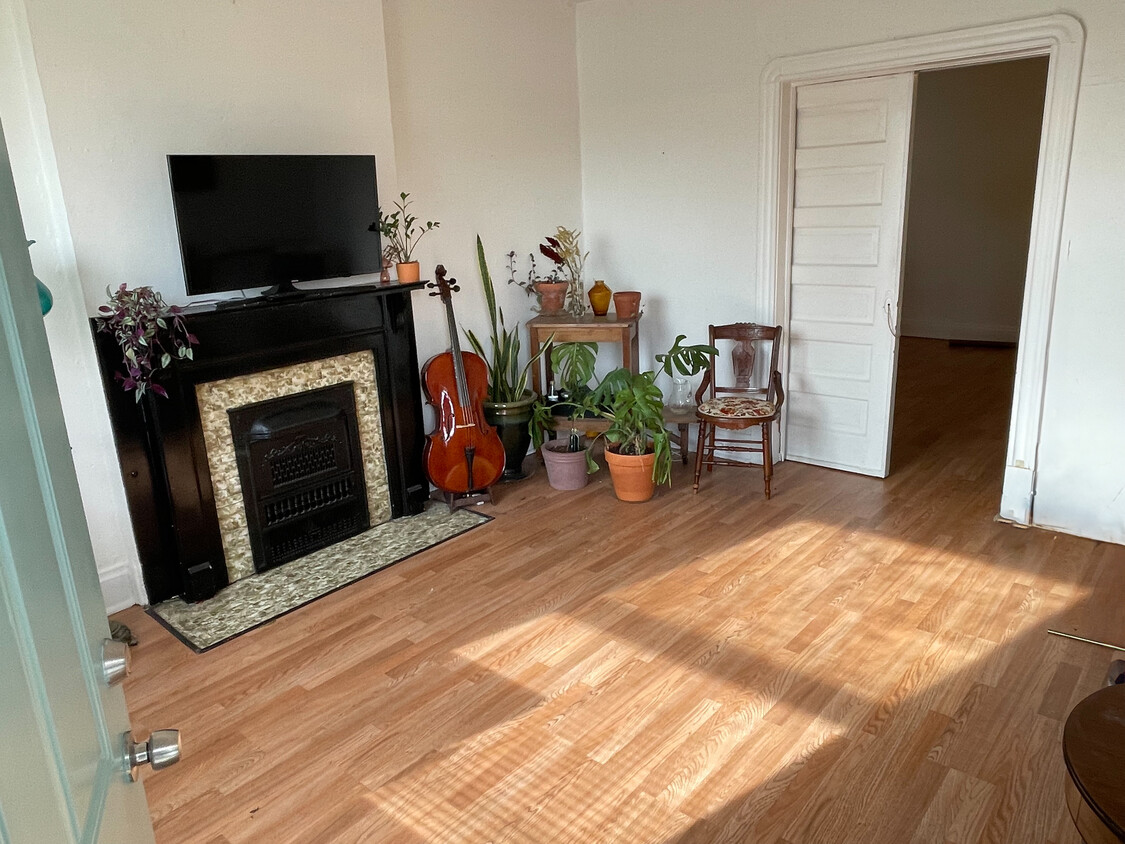 Front, south facing room. Featuring a decorative fireplace & pocketdoor. - 5313 Magnolia Ave