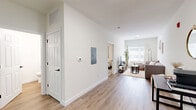 Located at 221 Waldron St in West Lafayette, Indiana, this thoughtfully designed one-bedroom, one-bathroom unit offers a bright and contemporary living experience. The open-concept layout seamlessly connects the kitchen, dining, and living areas, maximizing the efficient use of space throughout. Light wood-tone flooring runs through the main living areas, complementing the crisp white walls and creating a clean, modern aesthetic.

The kitchen is a standout feature, boasting gray shaker-style cabinetry, marble-look quartz countertops, a peninsula with an undermount sink, and stainless steel appliances including a range, microwave, and refrigerator. Pendant lighting with industrial-style fixtures adds character overhead, while a skylight brings in additional natural light.

The living room offers a comfortable, well-proportioned space with a large window that fills the room with natural light. The bedroom features soft carpet flooring, a window with draping curtains, and access to a generously sized walk-in closet with built-in shelving. A second closet provides additional storage convenience.

The full bathroom maintains the unit's clean design with light finishes and wood-tone flooring. A dedicated laundry area with full-size washer and dryer hookups adds everyday practicality to this well-appointed home.