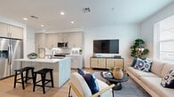 Located at 2045 Paseo Belluno in Chula Vista, CA, this two-story, 2-bedroom, 4-bathroom home offers a well-designed layout spread across two floors. The main level features an open-concept kitchen and living area with light wood-style flooring, recessed lighting, and large windows that invite natural light and neighborhood views. The kitchen is outfitted with stainless steel appliances including a gas range, built-in microwave, refrigerator with ice maker, and dishwasher, complemented by quartz countertops, a herringbone tile backsplash, and soft gray cabinetry with ample storage. The living area flows seamlessly from the kitchen, creating an inviting, connected space. Upstairs, the primary bedroom is a comfortable retreat with dual windows framing outdoor views and access to a walk-in closet with built-in shelving. The second bedroom is equally well-appointed with natural light. The home includes four bathrooms, one featuring a glass-enclosed walk-in shower with clean white tile surround. A dedicated hallway and staircase connect the floors efficiently. Throughout, the clean white walls, wood-tone flooring, and bright, airy palette create a cohesive and modern aesthetic.
