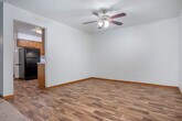 Located at 5994 Schroeder Rd in Madison, Wisconsin, this single-floor, 3-bedroom, 2-bathroom home offers a practical and comfortable layout. The interior is characterized by clean white walls, warm wood trim, and rich oak-toned accents that lend a consistent, cohesive feel throughout. The kitchen is well-equipped with abundant oak cabinetry, white countertops, wood-look flooring, a double sink, a black dishwasher, electric range, and a stainless steel refrigerator — providing ample storage and prep space. The open living area features neutral carpet, baseboard heating, and a window that brings in natural light with views of surrounding greenery. The generously sized primary bedroom offers plenty of room to furnish comfortably, also with carpeting, a baseboard heater, and a window overlooking the outdoors. The additional bedrooms are similarly appointed with carpet and natural light. Two hallways connect the rooms efficiently, complemented by two closets for storage. The bathrooms include one with a tub/shower combo and wood-look flooring, and another featuring a wide vanity with oak cabinetry, a large mirror, and louvered wood cabinet doors. Overall, the home presents a functional and well-maintained living environment with classic design details.