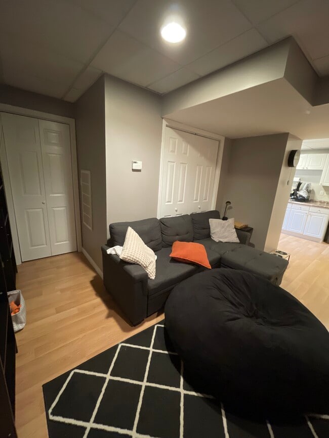 The living room area with storage behind the couch area and in the tv storage set. - 18 Old Neck Ct