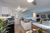 Located in Westminster, CO, this two-bedroom, two-bathroom unit offers a well-designed single-floor layout with an efficient use of space throughout. The open-concept kitchen and living area serves as the heart of the home, where white shaker cabinets, dark countertops, stainless steel appliances, and a peninsula with a deep basin sink create a functional and modern cooking space. Track lighting illuminates the kitchen, which flows seamlessly into a comfortable living room featuring wood-style flooring and access to a private balcony through sliding glass doors — bringing in natural light and outdoor views of surrounding greenery. The primary bedroom is a spacious retreat with a sliding closet, warm neutral tones, and wood-style flooring. The second bedroom features a soft blue accent wall and its own sliding closet with built-in shelving. Both bathrooms include tub-shower combinations. The unit also includes four closets for generous storage, a dedicated utility room, and a hallway connecting all areas. Textured ceilings are consistent throughout, adding a characteristic finish to the overall interior.