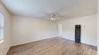 Located at 200 Robert St in New Smyrna Beach, Florida, this one-bedroom, one-bathroom unit offers a practical and well-organized single-floor layout. Throughout the space, wood-look plank flooring provides a clean, cohesive aesthetic, complemented by crisp white walls and textured ceilings that add subtle character.

The living room is an open, airy space anchored by a ceiling fan with integrated lighting, offering comfortable airflow year-round. A window allows natural light to filter in, brightening the room. The bedroom mirrors this bright, functional design, featuring its own window with blinds, a wall-mounted AC unit for climate control, and direct access to a dedicated walk-in closet complete with built-in shelving for organized storage.

The galley-style kitchen is efficiently designed, with white cabinetry lining both walls, a gas range, overhead range hood, and a full-size refrigerator. Light wood-look flooring and recessed overhead lighting keep the space feeling clean and bright.

The bathroom is finished in an all-white palette, featuring a tub-shower combination with tiled surround, a white vanity with countertop storage, and wood-look flooring that ties the space together with the rest of the unit. Overall, this unit delivers a clean, functional living experience in a convenient New Smyrna Beach location.