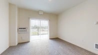 Located at 5708 S Spotted Rd in Spokane, WA, this one-bedroom apartment offers a well-organized, efficiently designed layout across a single floor. The living room is carpeted and bathed in natural light from a sliding glass door that opens to a private balcony, providing pleasant outdoor views of the surrounding landscape. A wall-mounted HVAC unit ensures year-round comfort in the living area.

The kitchen is a standout feature, outfitted with dark cabinetry, stainless steel appliances including a refrigerator, range, and microwave, and a peninsula counter with light-toned countertops. Light wood-style flooring in the kitchen contrasts neatly with the carpet in the adjoining living and bedroom areas.

The bedroom is a comfortable, well-proportioned space with soft carpet flooring, a large window that invites natural light and outdoor views, and a sliding closet that provides ample storage. The neutral, warm color palette throughout the unit lends a clean and cohesive ambiance.

A dedicated laundry room houses a full-size GE washer and dryer, adding a practical convenience rarely found in similarly sized units. The entry area features hard flooring and provides a clear transition point into the main living spaces. Overall, the unit presents a functional and modern living environment.