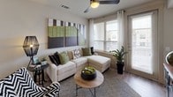 This two-story residence is designed with a contemporary aesthetic, combining clean lines and warm, neutral tones throughout. The open-concept living area serves as the heart of the home, featuring wood-look flooring, large windows with horizontal blinds, and a ceiling fan that enhances the bright, airy atmosphere. A sliding glass door provides access to the outdoors, allowing natural light to flow freely into the space.

The kitchen is well-equipped with stainless steel appliances, dark wood cabinetry, a subway tile backsplash, and a quartz peninsula with bar seating — ideal for casual dining or entertaining. Adjacent to the kitchen, the dining area accommodates a full-sized table and benefits from dual windows offering outdoor views.

Each bedroom features plush carpeting, ceiling fans, generous window placement, and access to well-appointed bathrooms. The primary bathroom includes a dual-sink vanity with dark wood cabinetry, quartz countertops, a separate glass-enclosed shower, and a soaking tub. A secondary bathroom offers a full tub-shower combination with clean white tile surrounds.

A dedicated home office provides a functional flex space complete with carpeted flooring, a ceiling fan, and ample natural light — suitable for focused work or study.