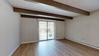 Located at 24 Rock Creek Dr in Delaware, Ohio, this two-story residence offers a practical and well-organized layout across two floors. The main level hosts a combined living, dining, and kitchen area finished with light hardwood-style flooring that extends throughout. Exposed ceiling beams lend architectural character to the open-concept space, while a sliding glass door fills the living area with natural light and provides views of the outdoors. The kitchen is equipped with stainless steel appliances — including a refrigerator, gas range, and built-in microwave — complemented by white shaker cabinetry, a stainless steel sink, and a white peninsula countertop ideal for additional prep or casual dining. A full bathroom with a tub/shower combo and hardwood-style flooring is also found on this level. Upstairs, two carpeted bedrooms offer a comfortable retreat, each featuring ceiling fans, natural light from windows, and baseboard heating. Both bedrooms include closet storage, and a second full bathroom serves the upper floor. A dedicated laundry area and additional closet space round out the home's functional offerings. The neutral color palette and clean finishes throughout create a bright, move-in-ready atmosphere.