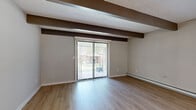 Located at 24 Rock Creek Dr in Delaware, Ohio, this two-story residence offers a practical and well-organized layout across two floors. The main level hosts a combined living, dining, and kitchen area finished with light hardwood-style flooring that extends throughout. Exposed ceiling beams lend architectural character to the open-concept space, while a sliding glass door fills the living area with natural light and provides views of the outdoors. The kitchen is equipped with stainless steel appliances — including a refrigerator, gas range, and built-in microwave — complemented by white shaker cabinetry, a stainless steel sink, and a white peninsula countertop ideal for additional prep or casual dining. A full bathroom with a tub/shower combo and hardwood-style flooring is also found on this level. Upstairs, two carpeted bedrooms offer a comfortable retreat, each featuring ceiling fans, natural light from windows, and baseboard heating. Both bedrooms include closet storage, and a second full bathroom serves the upper floor. A dedicated laundry area and additional closet space round out the home's functional offerings. The neutral color palette and clean finishes throughout create a bright, move-in-ready atmosphere.