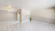 Located at 7575 Bissonnet St in Houston, Texas, this single-story, 3-bedroom, 2-bathroom home offers a clean and cohesive design highlighted by marble-look porcelain tile flooring throughout every room. The open combined living and dining area provides a bright, versatile space with neutral warm-beige walls, large windows with blinds that allow natural light to flow in, and a ceiling fan for added comfort. A pendant light fixture accents the dining zone, adding a subtle decorative touch. The kitchen features gray cabinetry, speckled quartz-style countertops, a double stainless steel sink with a brushed nickel faucet, and a dishwasher — offering both functionality and a tidy, updated aesthetic. Three well-sized bedrooms each include ceiling fans, ample natural light, and access to one of six closets spread throughout the home, providing generous storage. Both bathrooms are finished with marble-style wall and floor tiling, a tub-shower combination, vanity with speckled countertops, and clean white fixtures. Two hallways connect the layout efficiently. The home presents a consistent, modern-neutral palette throughout, making it a move-in ready space in the Westwood area of Houston.