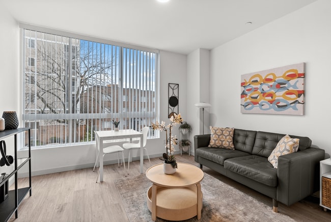 Light-filled living space with modern décor and expansive windows. - The Ruby Apartments