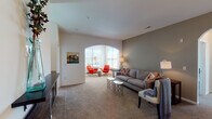 This single-floor residence offers a thoughtfully designed layout that balances comfort and functionality throughout. The entryway greets visitors with clean lines, light hardwood flooring, and a bright, welcoming atmosphere that sets the tone for the rest of the home.

The spacious living area is a standout feature, defined by a distinctive arched passageway that connects two lounge zones. One side is bathed in natural light from a large bank of windows, while the other is anchored by a warm, sage-toned accent wall and soft carpeting underfoot. Together, these areas create an inviting and versatile entertaining space.

The kitchen is well-equipped, featuring rich dark cabinetry, granite-style countertops, and a full suite of stainless steel appliances including a refrigerator, range, and over-the-range microwave. Light hardwood flooring ties the kitchen neatly to the entryway.

The primary bedroom offers a peaceful retreat with a soothing green accent wall and soft carpet, while a second bedroom provides ample natural light through dual windows with outdoor views. A dedicated home office with large windows and carpet flooring adds valuable flexibility to the floor plan.

The full bathroom is finished with tile flooring, dark cabinetry with a white countertop vanity, and a tub-shower combination, completing this well-rounded and comfortable residence.