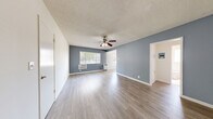 Located on Venice Boulevard in Los Angeles, this well-appointed 1-bedroom, 1-bathroom unit offers a thoughtfully designed single-floor layout. Light wood-look flooring flows throughout, complementing the cool blue-gray accent walls and crisp white trim found across the living spaces. The living room is open and airy, featuring a ceiling fan with light fixture, a textured ceiling, and windows dressed with horizontal blinds that invite natural light while maintaining privacy. Wall-unit air conditioning and a wall heater provide year-round climate comfort. The kitchen is a standout, showcasing powder-blue cabinetry, open shelving, a mosaic tile backsplash, white quartz countertops, a stainless steel sink, and a full suite of stainless steel appliances including a gas range and refrigerator. An adjacent windowed nook provides additional dining or flex space. The bedroom offers a relaxed atmosphere with a ceiling fan, blue-gray accent wall, natural light, and a mirrored sliding-door closet for ample storage. The bathroom features floor-to-ceiling travertine-style tile surrounding a soaking tub and shower combo with a glass enclosure. A connecting hallway ties the layout together efficiently, completing this clean and contemporary Los Angeles residence.