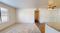 Located at 710 Wimbledon Dr in Lodi, CA, this single-floor, 2-bedroom, 1-bathroom residence offers a practical and comfortable layout. The combined kitchen and living area serves as the heart of the home, where wood-look flooring transitions seamlessly into the carpeted living space. A ceiling fan overhead and natural light from a nearby window keep the area bright and airy. The galley-style kitchen is well-equipped with white appliances including a range, refrigerator, and dishwasher, complemented by ample cabinetry, a stainless steel sink, and neutral countertops. Mirrored sliding doors add a sense of depth to the space. Both bedrooms are carpeted and receive natural light through windows fitted with blinds. The primary bedroom offers a generous footprint, while the second bedroom features a closet with a built-in shelf and rod for convenient storage. A hallway connects the bedrooms to the full bathroom, which includes a tiled shower-tub combination with updated brushed nickel fixtures and wood-look flooring. The unit's neutral color palette and clean finishes provide a versatile backdrop, making it easy to personalize.