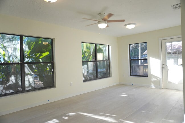 Spacious sun-filled living room with fans and outdoor access for Yankeetown gatherings. - 33 63rd St