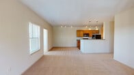 Located at 4061 Calderwood Dr in Aiken, South Carolina, this single-floor home offers a well-designed layout with a comfortable, functional flow throughout. The open-concept living and dining area is generously sized, featuring soft carpeting, crown molding, and track lighting. Large windows allow natural light to fill the space, and a glass-paneled door leads to an outdoor area, enhancing the sense of openness.

The kitchen runs adjacent to the living area and is equipped with warm honey-toned cabinetry, dark granite-style countertops, black appliances including a range, microwave, and refrigerator, and a peninsula with pendant lighting overhead. Wood-look flooring grounds the kitchen, providing a clean contrast to the carpeted living spaces.

The bedrooms are carpeted and bright, each featuring ceiling fans and windows with outdoor views of surrounding trees. One bedroom includes a spacious walk-in closet outfitted with wire shelving for organized storage. The bathroom features a full tub and shower combination with a tiled surround, wood cabinetry, and wood-look flooring. A dedicated laundry area houses a full-size washer and dryer with overhead shelving, adding practical convenience to everyday living.