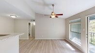This single-floor residence in Red Bank, Tennessee offers a well-organized layout comprising two bedrooms, two bathrooms, a combined kitchen and living area, and a dedicated closet. Light wood-style flooring runs throughout the unit, creating a cohesive and clean aesthetic across all rooms.

The open-concept living area is bright and airy, benefiting from multiple double-hung windows that frame views of surrounding greenery and allow generous natural light to fill the space. A ceiling fan with a built-in light fixture is centrally positioned overhead. The kitchen features a galley-style configuration with white shaker cabinetry, white quartz-style countertops, a stainless steel double sink, and stainless steel appliances including a refrigerator, electric range, microwave, and dishwasher. A peninsula counter separates the kitchen from the living area.

Both bedrooms include ceiling fans, built-in closets with shelving and hanging rods, and windows with blinds. The bathrooms are finished with white cabinetry, white countertops, tub-shower combinations with tiled surrounds, and vanity lighting. The overall color palette of warm beige and white tones gives the unit a neutral, move-in-ready appearance.