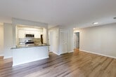Located at 2 Observation Court in Germantown, MD, this well-appointed one-bedroom, one-bathroom unit offers a thoughtfully designed single-floor layout. The open-concept living and kitchen area serves as the heart of the home, where rich hardwood-style flooring flows throughout, complemented by neutral wall tones that create a clean, welcoming atmosphere. The kitchen is a standout feature, equipped with stainless steel appliances including a refrigerator, range, and microwave, white cabinetry, and a granite-topped peninsula with an integrated sink — ideal for both cooking and casual dining. The living area opens directly onto a private balcony through sliding glass doors, bringing in natural light and outdoor views. The bedroom is a comfortable retreat with soft carpeting, a closet with sliding doors, and a window that frames views of the surrounding greenery. The full bathroom includes a tiled shower-tub combination with crisp white finishes. A dedicated closet provides additional storage. With its modern updates, practical layout, and inviting finishes throughout, this unit offers a comfortable and functional living experience in a convenient Germantown location.