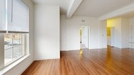 Located at 3214 Dunlap Ln in Mechanicsburg, PA, this well-appointed 2-bedroom, 2-bathroom residence offers a thoughtfully designed single-floor layout. Rich hardwood flooring flows throughout the main living areas, anchoring the open-concept living room and kitchen space. The kitchen is a standout feature, showcasing white cabinetry, granite countertops, a central island with a sink, pendant lighting, and a full suite of stainless steel appliances including a refrigerator, range, and built-in microwave. Large windows in the living area flood the space with natural light and offer pleasant outdoor views, complemented by a glass-paned exterior door.

The spacious primary bedroom features plush carpeting, multiple windows, and access to a generous walk-in closet with wire shelving. The second bedroom is equally comfortable, also carpeted and well-lit. Both bathrooms are cleanly finished with hardwood-style flooring and include tub/shower combinations. A dedicated laundry room houses a full-size washer and dryer. The neutral color palette and clean architectural lines throughout lend the space a bright, move-in-ready ambiance suitable for a variety of lifestyles.