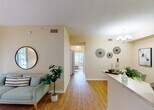 Located at 4495 Emerald Vista in Lake Worth, Florida, this single-floor residence offers a well-organized layout designed for comfortable everyday living. The living room serves as a welcoming centerpiece, featuring warm beige walls, wood-style flooring, and a sliding glass door that opens to a private outdoor patio, allowing natural light to fill the space. Adjacent to the living area, the dedicated dining space is defined by a chandelier overhead and offers a cozy setting for meals.

The galley-style kitchen is efficiently designed with white cabinetry, light countertops, a double sink, and white appliances, with additional utility space conveniently located just beyond.

The unit includes two bedrooms, each carpeted and bathed in natural light from large windows with outdoor views of the surrounding greenery. Both rooms offer a calm, restful atmosphere with ample wall space and closet access. The full bathroom features wood-style flooring, a white vanity with cabinet storage, a large mirror with overhead lighting, and a shower-tub combination.

Throughout the home, textured ceilings, neutral warm tones, and consistent flooring materials create a cohesive and inviting aesthetic. A central hallway connects all rooms, contributing to a functional and efficient flow across the entire residence.