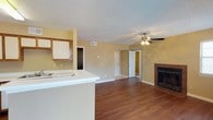 Located at 330 Cross Park Dr in Pearl, Mississippi, this single-floor unit offers a practical and comfortable layout designed for everyday living. The open-concept living and dining area is a central highlight, featuring rich hardwood-style flooring, warm neutral-toned walls, and a ceiling fan with light fixture. A tile-surround fireplace anchors one wall of the living room, adding a cozy focal point to the space. Multiple windows dressed with horizontal blinds allow natural light to fill the room.

The kitchen is efficiently designed with wood-trimmed cabinetry, white appliances including a refrigerator, electric range, built-in microwave, and a double sink. A peninsula counter extends into the living area, providing additional prep space and a natural division between the kitchen and living zones.

The bedrooms are carpeted for comfort and each includes a ceiling fan. The rooms offer a quiet, functional atmosphere with closet access and natural light from individual windows. Two bathrooms serve the unit, each featuring a tub-shower combination, vanity with a wide mirror, and clean, straightforward finishes. Textured ceilings are consistent throughout the unit, contributing to its residential character.