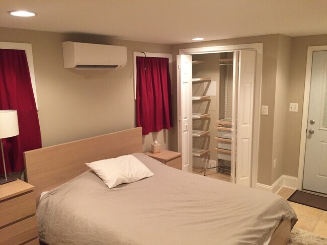 Dormitorio espacioso con ventanas seguras, puerta exterior segura, dos armarios grandes, incluido uno con sistema Elfa, tocador grande, mesita de noche, alfombra, lámparas, unidad HVAC Minisplit y espejo. - 43 Girard St. NE