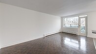 Located at 200 Ridley Blvd in Toronto's Lawrence Park neighbourhood, this one-bedroom, one-bathroom unit offers a well-considered layout across a single floor. Gleaming dark parquet flooring runs throughout the living spaces, adding warmth and a timeless character to the clean, white-walled interior.

The open living room is bright and airy, benefiting from large windows that frame outdoor tree-lined views and a door providing direct access to an exterior space. Baseboard heating runs along the perimeter, ensuring year-round comfort. The room offers generous proportions, making it a versatile and functional living area.

The galley-style kitchen is thoughtfully renovated, featuring white cabinetry, dark countertops, stainless steel appliances including a fridge, stove, and microwave, and a classic white subway tile backsplash. Ample upper and lower cabinet storage makes this kitchen as practical as it is attractive.

The bedroom is a comfortable, well-sized retreat with its own window overlooking the outdoors and a radiator for warmth. Mirrored sliding closet doors add depth and light to the space.

The bathroom is finished with floor-to-ceiling white subway tiles, a soaker tub with overhead shower, a modern vanity, and a mirror — presenting a clean, crisp aesthetic throughout.