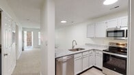 Located at 3401 Bremer Hall Ct in Raleigh, NC, this well-appointed one-bedroom, one-bathroom residence offers a thoughtfully designed single-floor layout with a clean, neutral palette throughout. The open-concept kitchen and living area serves as the heart of the home, where the kitchen impresses with granite countertops, crisp white cabinetry, stainless steel appliances including a dishwasher, range, microwave, and refrigerator, and a peninsula that connects seamlessly to the carpeted living space. Recessed lighting illuminates the kitchen, while the living area benefits from natural light streaming through a large window. A French door opens directly onto a private balcony, extending the living space outdoors and offering pleasant views of surrounding greenery. The bedroom is a comfortable retreat featuring plush carpet, a ceiling fan, and a window that brings in natural light. A dedicated closet provides organized storage. The bathroom is clean and functional, equipped with a full soaking tub and shower combination with brushed nickel fixtures and safety bars. Wood-look flooring in the kitchen and bath areas complements the soft carpet found throughout the living and sleeping spaces, creating a warm and cohesive ambiance.