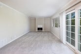 Located at 2520 Ryan Rd in Concord, CA, this well-appointed 2-bedroom, 2-bathroom single-floor home offers a comfortable and functional layout. The living room serves as the heart of the home, featuring a classic fireplace, crown molding, plush carpeting, and large windows with sliding glass doors that invite natural light and provide views of the surrounding greenery. A ceiling fan adds to the room's comfort, while a stacked in-unit washer and dryer unit is conveniently tucked nearby.

The kitchen connects seamlessly to the living area via a pass-through opening with granite countertops, and is equipped with stainless steel appliances, including a refrigerator and electric range, set against clean white cabinetry.

The spacious primary bedroom features crown molding, a ceiling fan, natural light from a window overlooking lush trees, and a louvered bifold closet. The second bedroom also includes a ceiling fan, carpeting, and dual bifold closets providing ample storage. Both bathrooms are finished with granite-topped vanities, tile flooring, and white cabinetry, with one bath featuring a full tub-shower combination.

The home's neutral color palette and consistent finishes throughout create a clean, cohesive ambiance.