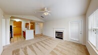 Located at 9905 Windsor Club Dr in Riverview, FL, this single-story, 3-bedroom, 1-bathroom home offers a well-designed layout with comfortable living spaces throughout. The living room is a standout feature, showcasing soaring vaulted ceilings, a ceiling fan, a tiled fireplace with a white surround mantel, and a large window that fills the room with natural light. Plush carpeting runs throughout the main living areas and bedrooms, adding warmth underfoot. The kitchen is open and functional, featuring warm wood cabinetry, stainless steel appliances including a refrigerator and microwave, a tile backsplash, and a peninsula breakfast bar illuminated by stylish pendant lights — seamlessly connecting to the dining area. The dining room offers crown molding and an elegant chandelier. Each of the three bedrooms is carpeted and equipped with a ceiling fan and window for natural light, with the generously sized primary bedroom providing ample space. The bathroom features light wood-look vinyl flooring, a white vanity, and a tub/shower combo with a bright window. A dedicated laundry room accommodates a full-size washer and dryer. Crown molding details are present throughout, adding a refined touch to this well-appointed Riverview home.