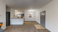 Located at 377 Athens Way in Nashville, Tennessee, this single-floor residence offers a well-designed layout that balances functionality and comfort. The open-concept living and dining area greets you at entry with a tiled foyer transitioning to plush carpeting, neutral white walls, and a decorative pendant light fixture. A breakfast bar connects the living space seamlessly to the kitchen, making it ideal for entertaining.

The galley-style kitchen is thoughtfully appointed with warm hardwood flooring, granite countertops, gray cabinetry with brushed hardware, a stainless steel double-basin sink with a gooseneck faucet, and white appliances including a refrigerator, range, microwave, and dishwasher. A dedicated in-unit laundry area is conveniently accessible directly from the kitchen corridor.

The living room benefits from a ceiling fan, soft carpeting, and a set of French doors that open to an outdoor area, filling the space with natural light. The bedroom is generously sized with carpeted flooring, a ceiling fan, and direct access to a private bathroom and a separate closet. The bathroom features granite countertops, gray vanity cabinetry, a large mirror, and a shower-tub combination. Throughout the unit, consistent gray door and trim accents provide a cohesive, modern aesthetic.