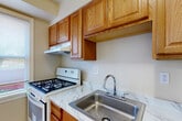 Located at 5705 43rd Ave in Hyattsville, MD, this single-floor unit offers four bedrooms, one bathroom, and a kitchen, all thoughtfully arranged across a compact yet efficiently utilized footprint. Throughout the home, light wood-look laminate flooring and warm neutral wall tones create a clean, cohesive aesthetic complemented by crisp white trim and six-panel doors with classic brass hardware.

The bedrooms vary in size, with the primary bedroom offering a generous layout, dual windows that invite abundant natural light, a ceiling fan, and a classic cast-iron radiator for heating. Additional bedrooms are well-proportioned, each featuring windows with blinds, radiator heating, and the same consistent flooring and neutral palette.

The kitchen is equipped with warm oak cabinetry, a marble-patterned countertop with a stainless steel sink, and a full-size refrigerator, alongside open shelving that adds functional storage space. The flooring transitions to a marble-look tile in this area.

The bathroom features a full bathtub and shower combination, a toilet, and a window with blinds that provides natural ventilation. Two hallways connect the rooms, ensuring a smooth and logical flow throughout the unit. Overall, the space presents a practical and well-maintained living environment.