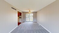 This two-story residence in Pontiac, Michigan, offers a practical and well-organized layout spread across two floors. The main level houses the living room, kitchen, and hallway, while the upper floor is dedicated to the three bedrooms, bathroom, and closet, connected by a staircase.

The living room is a comfortable, open space finished with neutral gray carpeting and capped by a ceiling fan. A full-height sliding glass door floods the room with natural light and provides direct outdoor views and access. The kitchen is adjacent and open to the living area, featuring warm oak cabinetry, marble-patterned laminate countertops, a stainless steel sink beneath a window, and white appliances including a range and dishwasher.

Upstairs, three carpeted bedrooms offer quiet retreats, each with windows fitted with vertical blinds that allow natural light while maintaining privacy. The primary bedroom provides a generous amount of space. The shared bathroom includes a full tub-shower combination with white tile surround and chrome fixtures. A hallway closet on the upper level provides additional storage. The overall palette of neutral grays and warm wood tones gives the space a clean, cohesive character throughout.