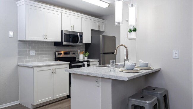 Bright kitchens adorned with gleaming stainless-steel appliances and marble-like countertops. - Carrington Lane