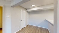 Located at 1890 N Lennox St in Olathe, Kansas, this one-bedroom, one-bathroom unit offers a thoughtfully organized single-floor layout that maximizes every square foot. The open-concept living, dining, and kitchen area forms the heart of the home, featuring warm wood-look LVP flooring, neutral-toned walls, and a textured ceiling throughout. Natural light filters in through a large window in the living area, complementing the bright, airy feel of the space.

The kitchen is well-appointed with gray shaker-style cabinetry, marble-look countertops, stainless steel appliances including a refrigerator, range, and microwave, and a peninsula that doubles as a breakfast bar. A dedicated pantry provides additional storage convenient to the kitchen.

The bedroom is a comfortable, carpeted retreat featuring a ceiling fan, a sliding glass door with outdoor views, and access to multiple closets offering generous wardrobe storage. Louvered closet doors add a classic touch.

The bathroom is clean and functional, featuring a white vanity with gray cabinetry, a tub-shower combo, and wood-look flooring. A utility room rounds out the layout, adding practical in-unit functionality. This unit combines efficient design with modern finishes throughout.