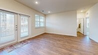 Located at 7121 Elroy Rd in Austin, TX, this single-story 2-bedroom, 2-bathroom home offers a well-designed, functional layout with thoughtful finishes throughout. The open-concept living and kitchen area serves as the heart of the home, anchored by warm wood-style flooring and filled with natural light from large windows and French doors that open to the outdoors. The kitchen is a standout feature, showcasing crisp white shaker cabinetry, gleaming granite countertops, a central island with a built-in sink, and a full suite of stainless steel appliances. Ample pantry storage is provided by a pair of double doors adjacent to the range. The living area flows seamlessly, offering a bright and open atmosphere. Both bedrooms are carpeted and generously sized, with large windows that invite natural light and views of the surrounding neighborhood. The primary bedroom includes a walk-in closet with built-in shelving. The two bathrooms are finished with white cabinetry, granite countertops, wood-style flooring, and tub-shower combinations with decorative curtains. Additional storage is thoughtfully incorporated throughout the home, completing this clean, contemporary residence in the Austin area.