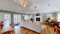 Located at 1 Turtle Lake Dr in Birmingham, Alabama, this single-floor property offers a thoughtfully designed layout that balances comfort and functionality. The main living area is anchored by soaring vaulted ceilings and a striking white brick fireplace, creating a warm and inviting focal point. Rich hardwood flooring flows throughout, complementing the sage green walls that lend a calm, cohesive aesthetic. Multiple sets of French doors line the living space, flooding the room with natural light and providing views of the surrounding outdoor areas. Brass pendant lighting and ceiling fans add stylish finishing touches overhead.

Adjacent to the living room, the dining area features vaulted ceilings of its own and centers around a natural live-edge wood dining table, with additional French doors offering continued access to the outdoors. Glass-paned interior French doors connect the dining space seamlessly to the living room.

The galley-style kitchen is well-equipped with warm wood cabinetry, dark countertops, black appliances, crown molding, and a peninsula that provides additional seating.

A dedicated fitness room rounds out the layout, outfitted with rubber flooring, free weights, resistance equipment, and large windows that bring in natural light and outdoor views — making it a standout feature of this versatile property.