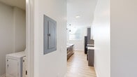 Located at 1418 Carroll St in St. Louis's vibrant 63104 zip code, this thoughtfully designed single-floor unit offers a clean, modern aesthetic with high-quality finishes throughout. The heart of the home is a well-appointed kitchen featuring a large center island with a white quartz countertop and undermount sink, two sleek pendant lights, a classic tile backsplash, two-tone cabinetry in white and charcoal gray, and a full suite of stainless steel appliances including a refrigerator, range, and dishwasher. Natural light flows in through multiple windows fitted with blinds. The open layout transitions seamlessly from the kitchen into a spacious living area with light wood-tone flooring. The unit includes multiple bedrooms, each carpeted with generous closet space — one featuring double windows for added brightness. Bathrooms are finished with modern vanities, quartz countertops, undermount sinks, and large mirrors. A dedicated laundry area accommodates a full-size washer and dryer. Additional practical features include an electrical panel access point and recessed lighting. The neutral color palette and contemporary design details make this a well-equipped, move-in ready space.