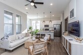 Located in Meridian, Idaho, this thoughtfully designed single-story home combines modern aesthetics with functional living. The open-concept main area seamlessly connects the living room, dining space, and kitchen, creating a bright and welcoming atmosphere flooded with natural light from multiple windows throughout.

The living room features wood-look flooring, a ceiling fan, and a welcoming entryway with a glass-panel front door. The kitchen is well-equipped with stainless steel appliances including a side-by-side refrigerator, electric range, and microwave. Two-tone cabinetry pairs white upper cabinets with warm wood lower cabinets, complemented by white countertops and a spacious island with bar seating. A dedicated pantry offers additional storage. The dining area, bathed in natural light, comfortably accommodates a full dining set.

The primary bedroom is generously sized with elevated windows providing privacy while maintaining natural light, and features plush carpeting. A second bedroom offers versatile use. Bathrooms are finished with wood-toned vanities, white countertops, and clean tile work. A hallway bathroom includes a walk-in shower and a separate tub/shower combination. The home's neutral color palette and cohesive modern design create a calm, inviting ambiance throughout.
