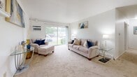 Located in West Allis, Wisconsin, this single-floor residence offers a thoughtfully arranged layout featuring two bedrooms, one bathroom, a living room, and a connecting hallway. The living room serves as the heart of the home, featuring plush wall-to-wall carpeting, crisp white walls, and a large sliding glass door that fills the space with natural light and provides views of the surrounding greenery. A built-in wall shelf adds a decorative touch, while the open flow into the dining area makes the space feel connected and functional. The primary bedroom is a comfortable retreat with a sliding closet, soft carpet flooring, and room for a full furniture arrangement. The second bedroom mirrors this warmth, featuring a window with natural light, carpet flooring, and ample space for a bed and storage. Both rooms offer a clean, neutral palette. The bathroom is well-appointed with tile flooring, a grey vanity with storage, a wall mirror, and a tub-shower combination. A hallway connects the rooms, maintaining an efficient and organized flow throughout the residence. Overall, the space presents a clean, light-filled, and functional living environment suited for comfortable everyday living.