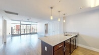 Located at 221 Harborside Dr in Schenectady, NY, this thoughtfully designed three-bedroom, three-bathroom residence offers an impressive blend of modern finishes and waterfront living. The open-concept kitchen and living area serves as the heart of the home, anchored by a substantial granite-topped island with rich dark wood cabinetry, pendant lighting, and stainless steel appliances. Hardwood flooring flows throughout the main living spaces, complemented by expansive floor-to-ceiling windows and sliding glass doors that flood the interior with natural light and open to a private balcony. From the balcony, sweeping views of the harbor, marina, and surrounding waterfront development create a striking backdrop. The living area is generously proportioned, with clean lines and a neutral palette throughout. Each of the three bedrooms features plush carpeting and dedicated closet space, with windows offering neighborhood views. The primary bedroom is a comfortable retreat with direct access to additional spaces. The three bathrooms are well-appointed, featuring a glass-enclosed walk-in shower in one and a full tub-shower combination in another, all finished with contemporary brushed nickel fixtures and light tile flooring. Additional conveniences include a dedicated laundry area and utility room, rounding out this well-appointed harborside residence.